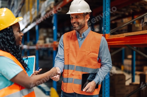 Preview: Man holds tablet confidently while shaking hands with colleague.