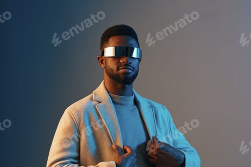 Preview: Stylish young African man with futuristic sunglasses in a trendy outfit, showcasing confidence