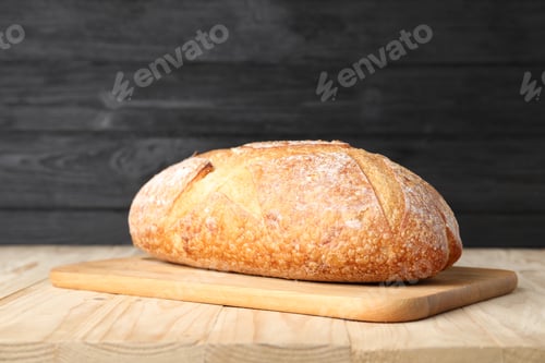 Preview: Loaf of fresh bread on light wooden table, closeup
