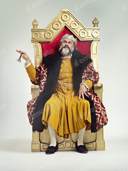 Preview: Servants Come hither. Studio shot of a richly garbed king sitting on a throne.
