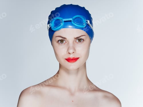 Preview: Beautiful woman with red lips in a blue swimming cap and glasses on her head