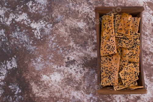 Preview: Crackers with black cumin on them in wooden tray on the right side