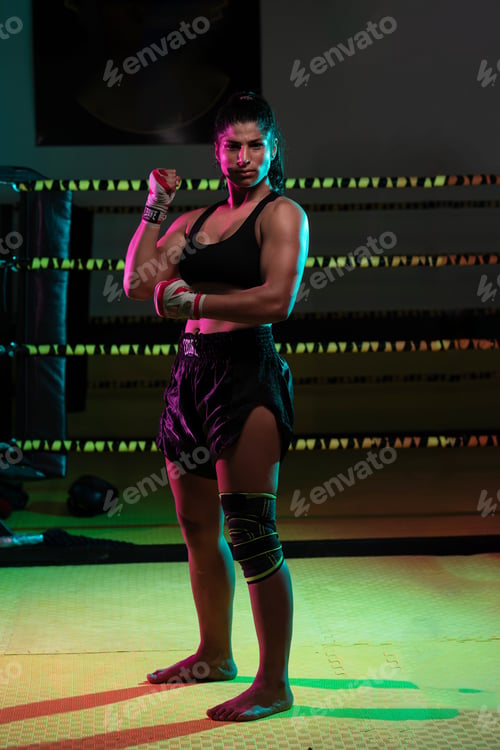 Preview: Portrait young Latina boxer woman wrapping hand with sport bandage on black background