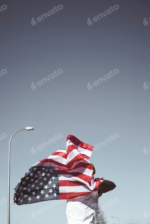 Preview: Casual man with American flag on street