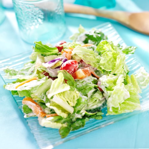 Preview: garden salad with fresh vegetables and ranch dressing on glass plate.