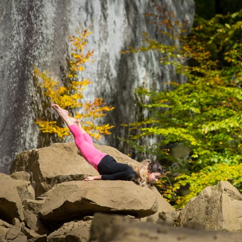 Preview: Sporty fit woman is practicing yoga on the boulder in the nature