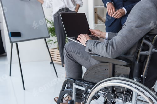Preview: cropped shot of disabled businessman working on laptop in office