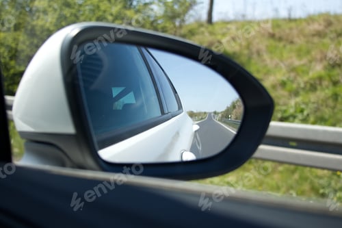 Preview: view of the mirror of a car that reflects the road