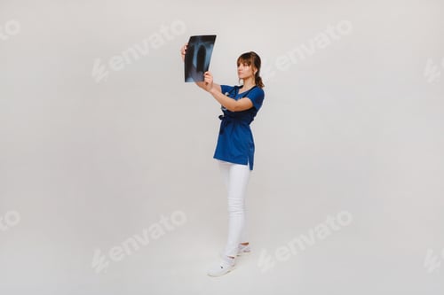 Preview: Female Brunette Doctor Looking at Tomography X-ray Film
