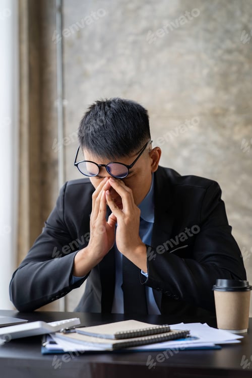 Preview: tired businessman sleepy and bored from sitting at a desk for a long time and has office syndrome