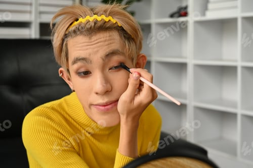 Preview: Smiling gay male beauty make up artist or blogger filming daily makeup tutorial.