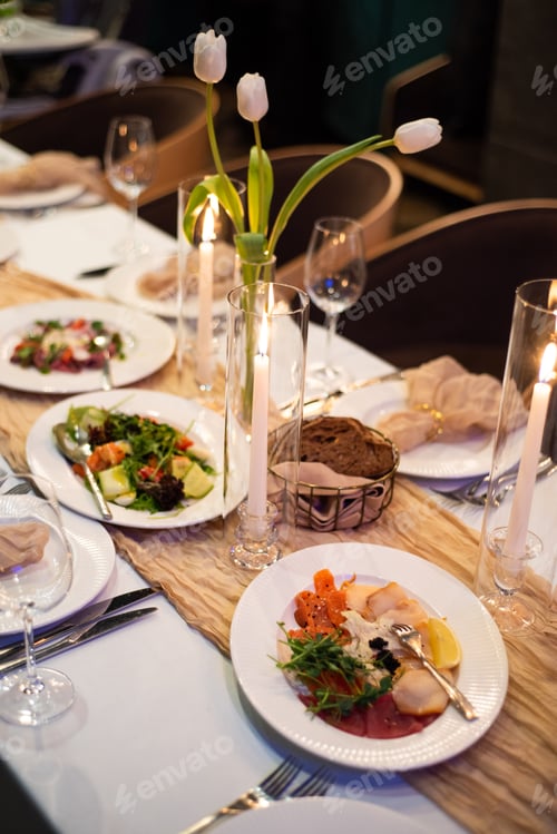 Preview: beautiful table setting with flowers and cutlery on wooden table at wedding or dinner. stylish table