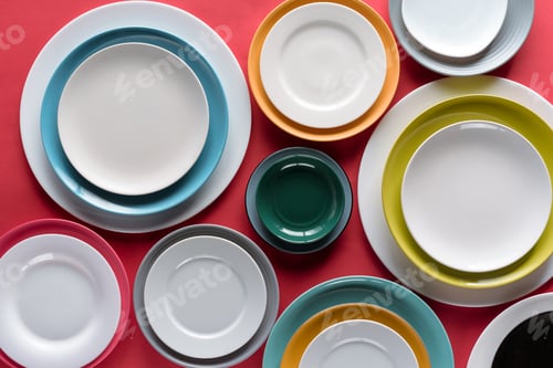 Preview: White and colorful plates of different sizes on red background