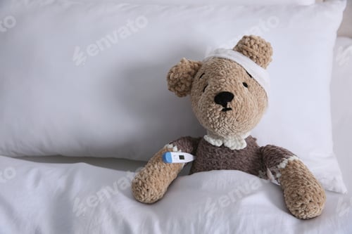 Preview: Cute toy bear with bandage and thermometer in bed, space for text. Children's hospital