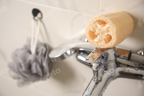 Preview: Grey shower puff and loofah sponge in bathroom, closeup