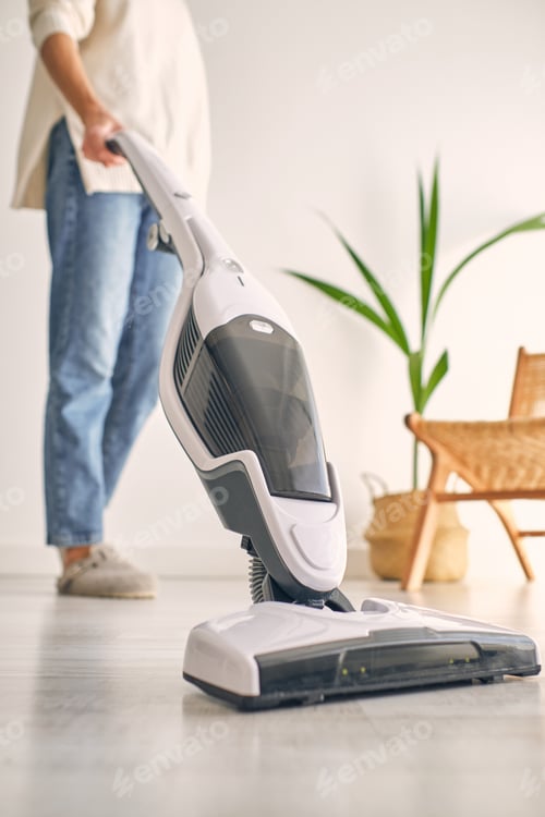 Preview: Crop unrecognizable female cleaning home with contemporary cordless vacuum cleaner