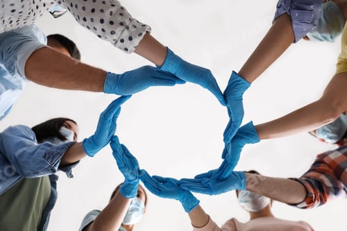 Preview: People in blue medical gloves showing circle with hands on light background, low angle view