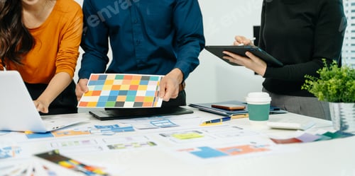 Preview: Close up view of UI developer team brainstorming on their project with laptop, smartphone and
