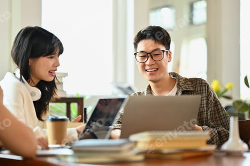Preview: Friendly asian man student doing group project or preparing presentation on laptop with classmates