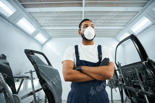 Preview: Handsome young mechanic confidently working in a modern auto repair workshop setting