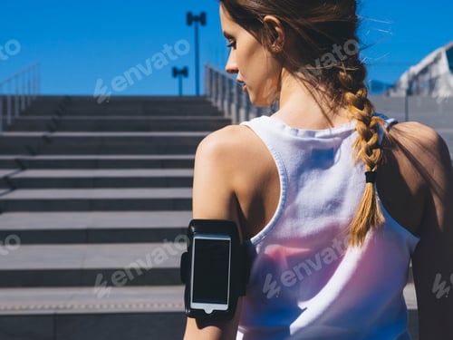 Preview: Young female athlete relaxing after running in a modern district