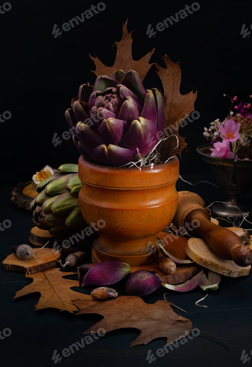 Preview: artichokes in a wooden mortar in dark atmosphere all focus