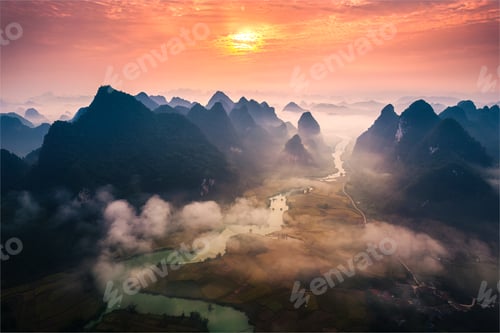 Preview: Sunrise over mountain range with foggy on rural village and river flows through in Phong Nam Valley