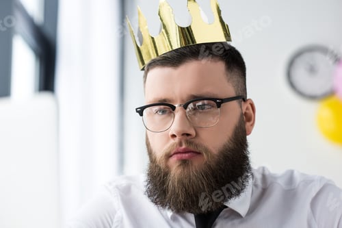 Preview: portrait of bearded businessman in eyeglasses with paper crown on head