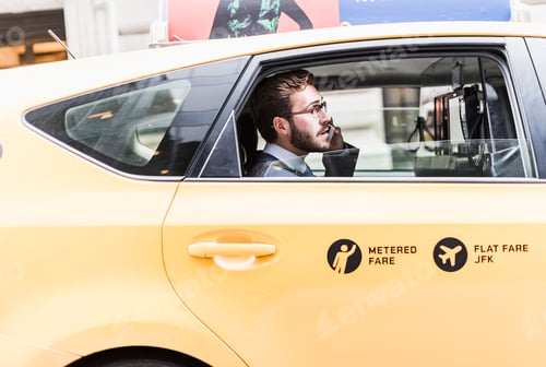 Preview: USA, New York City, businessman on cell phone in a taxi