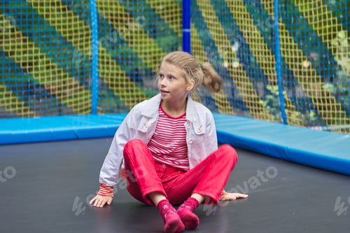 Preview: Girl child sitting on an outdoor trampoline