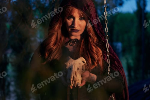 Preview: Woman disguised as a witch holding a skull in her hands