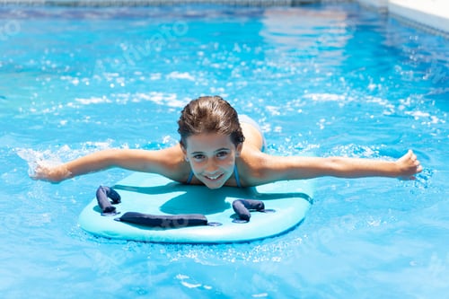 Preview: Cute girl playing with a bodyboard in a swimming pool
