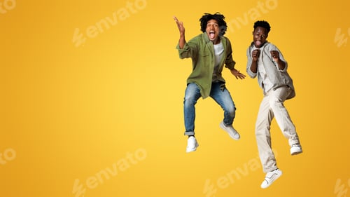 Preview: Crazy Mood. Two Overjoyed Black Guys Jumping Over Beige Studio Background