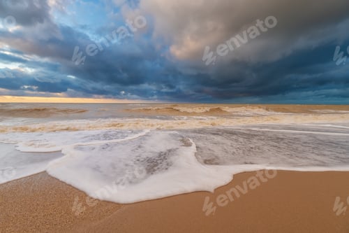 Preview: Sandy sea shore during the sunset and stormy weather.