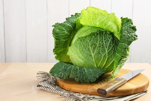 Preview: Fresh Savoy cabbage and knife on wooden table, closeup. Space for text