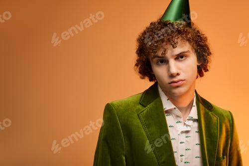 Preview: Curly teenage boy in a stylish green velvet blazer posing in a vibrant studio setting