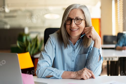 Preview: Smiling senior businesswoman, real estate agent, looking at camera in modern office