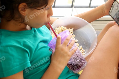 Preview: Child Eating Popcorn and Drinking Beverage Indoors