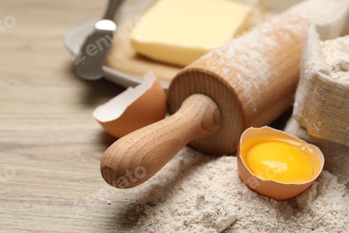 Preview: Rolling pin and different ingredients on light wooden table, closeup