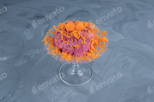 Preview: Beet and walnut salad garnished with carrot and served on a glass pedestal on marble background