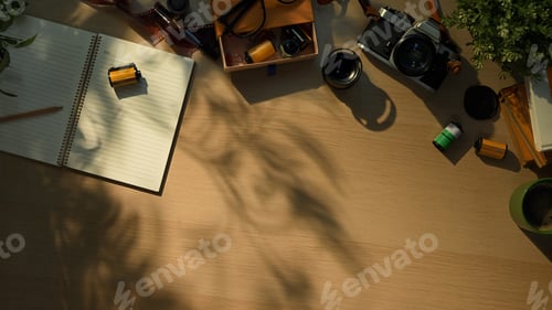 Preview: Creative workspace with vintage camera, notebook, and coffee cup in warm morning sunlight