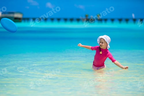 Preview: Adorable happy little girl have fun at shallow water on beach vacation