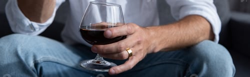 Preview: panoramic shot of man holding wine glass with red wine