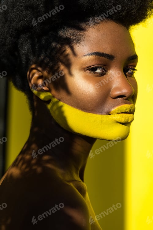Preview: beautiful african american woman with body art on yellow