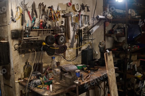 Preview: Middle Aged Caucasian Man Repairing Custom Bike in Workshop Surrounded by Tools