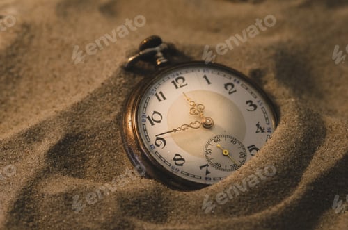 Preview: Vintage pocket watch on the sand, closeup.