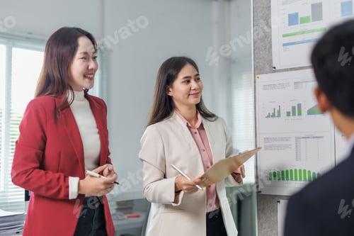 Preview: Asian businesswomen discussing company strategy and analyzing financial charts