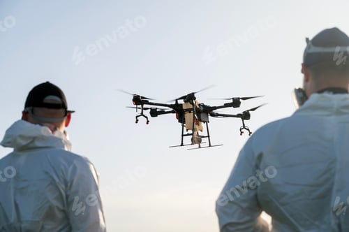 Preview: Drone operator, modern farmer flies drone over agricultural fields