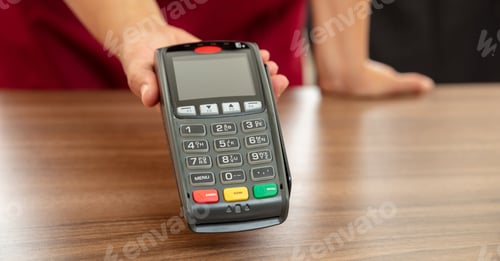 Preview: Cashier offering POS terminal for payment with credit card.