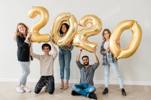 Preview: Group of five cheerful teenage friends showing number of new year